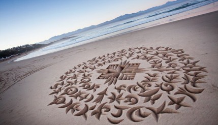 Artista faz complexa caligrafia na areia com técnica inovadora
